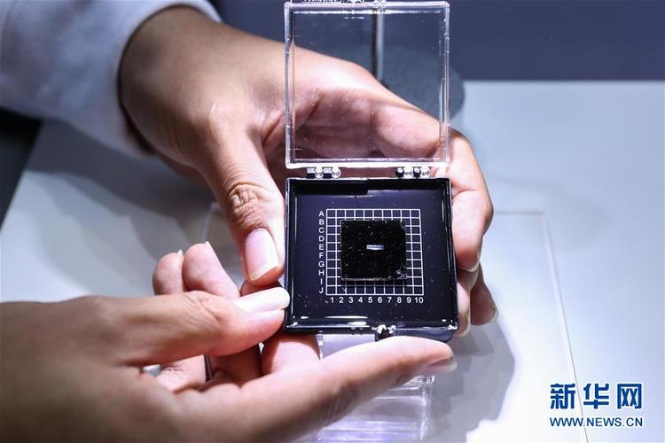 10月8日,工作人员在媒体开放日上展示光子人工智能芯片.